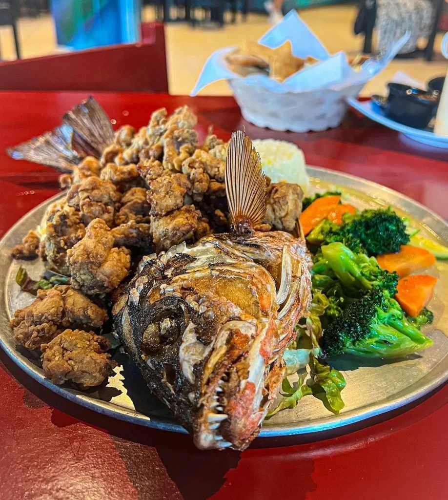 Platillo con un pescado frito y ensalada en restaurante de mariscos en playa