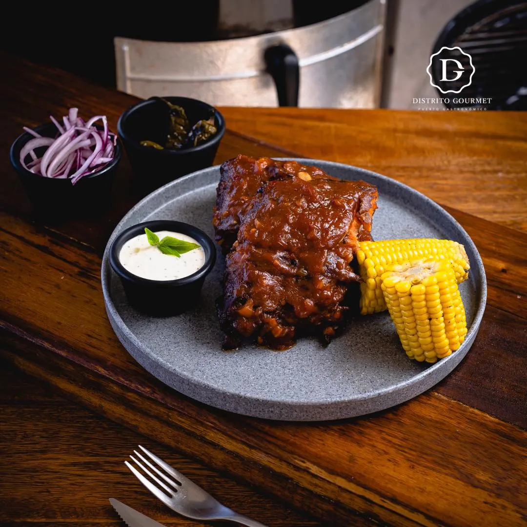 Costillas bañadas en salsa bbq acompañadas con un elote y aderezo