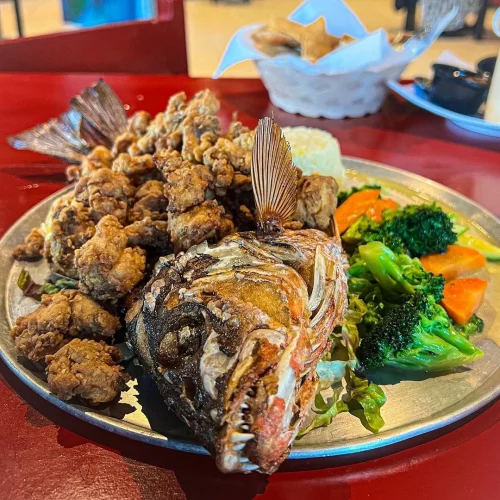 Platillo con un pescado frito y ensalada en restaurante de mariscos en playa