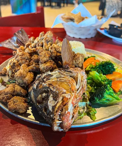 Platillo con un pescado frito y ensalada en restaurante de mariscos en playa