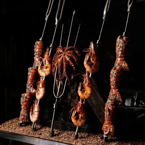 Platillos de mar, espadas con camarones, pulpos y lagostas a las brasas en el buffet bovinos steakhouse playa