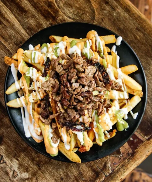 Papas fritas con carne asada en el restaurante el canibal